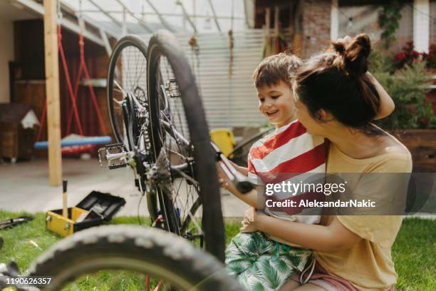 fietsen repareren met mijn moeder - bicycle tire stockfoto's en -beelden