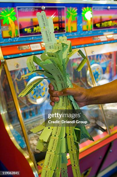 a handful of arcade game prize tickets. - winning ticket stock pictures, royalty-free photos & images