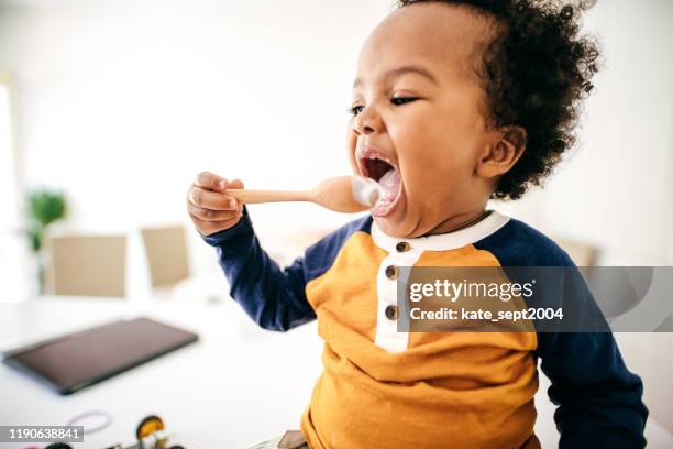 peuter yoghurt eten - baby eating yogurt stockfoto's en -beelden