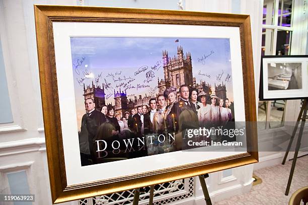 Signed and framed poster of Downton Abbey awaits auction during 'An Evening With Downton Abbey - Raising Money For Merlin - The Medical Relief...