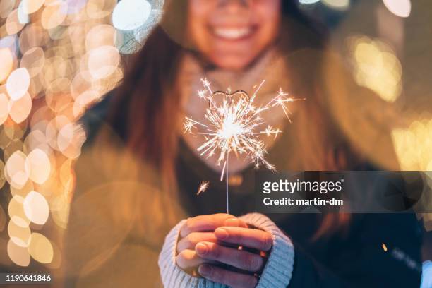 meisje houdt brandende sparkler tijdens kerstmis - illuminated stockfoto's en -beelden