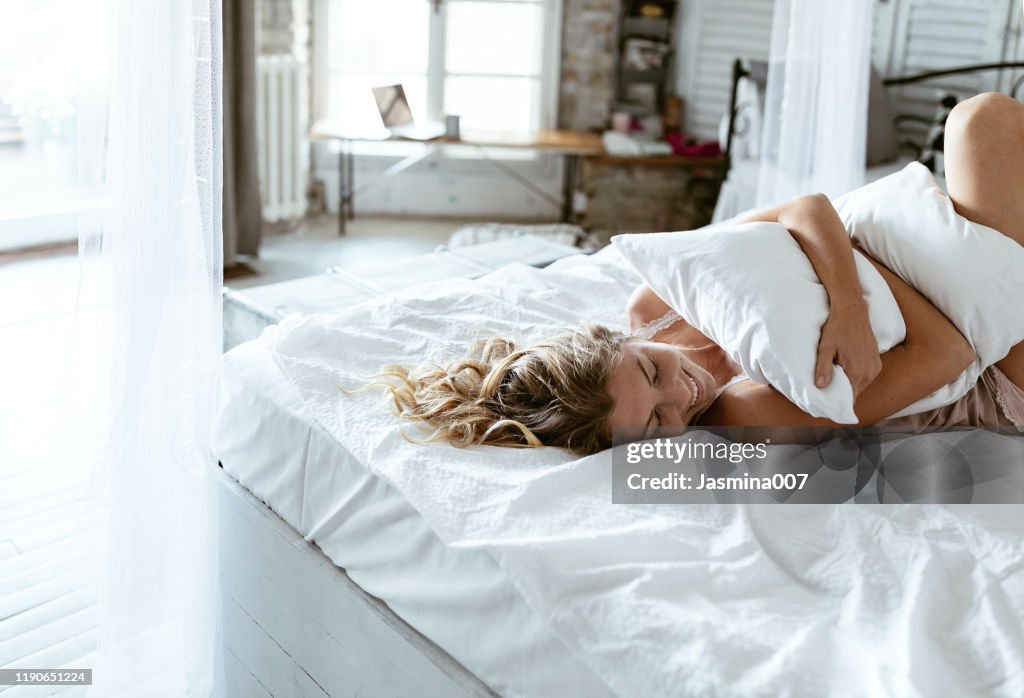 Portrait of young woman enjoying time in bed