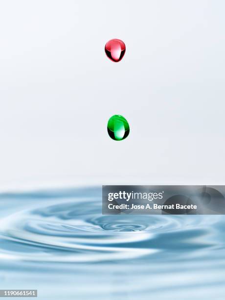 group of drops on line suspended in the air, falling down on a water surface on a white background. - onde sinusoïdale photos et images de collection