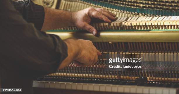 instrument technician repairing a piano - musical instrument repair stock pictures, royalty-free photos & images
