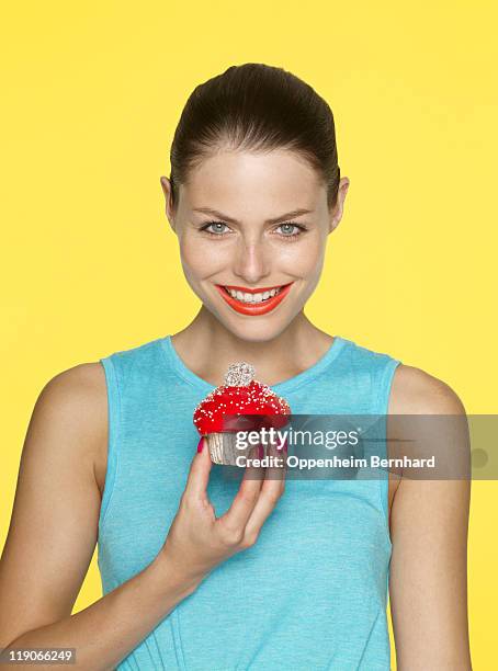 young female holding iced cake and smiling - sponge cake stock pictures, royalty-free photos & images