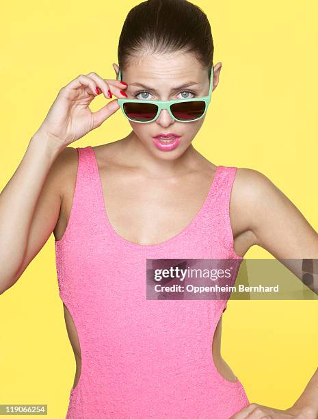 young female looking over her sun glasses - swimming costume stock pictures, royalty-free photos & images