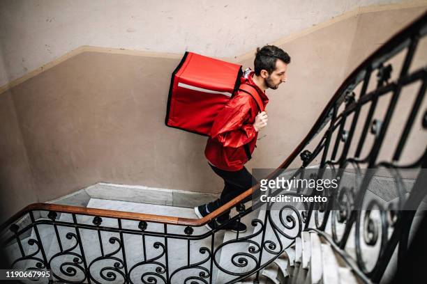 Delivery guy moving up on stairs in residential building
