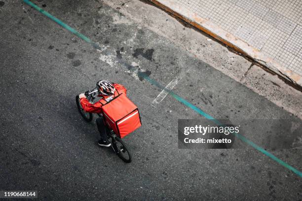 delivering food on bicycle in city - food delivery stock pictures, royalty-free photos & images