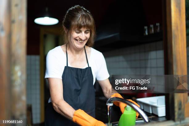 mature woman doing dishes - kitchen porter stock pictures, royalty-free photos & images