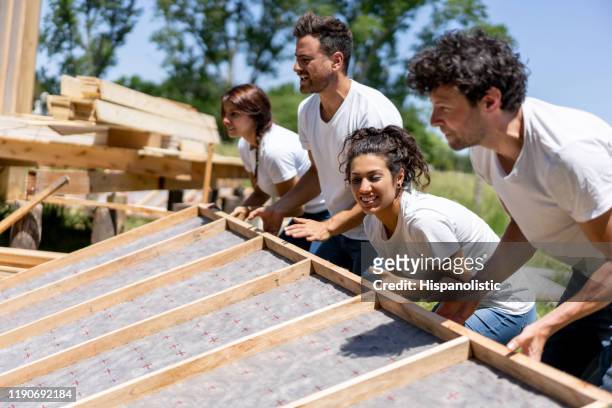 latin american volunteers working hard at a charity construction project - social issues stock pictures, royalty-free photos & images