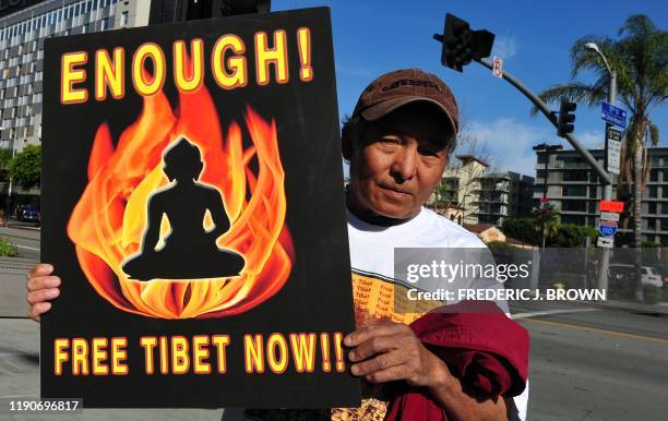 Tibetans and supporters of a "Free Tibet" hold placards while marching through downtown Los Angeles on March 10, 2012 in California, joining...