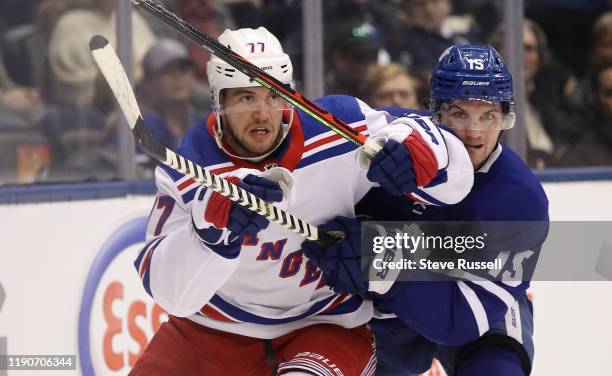 Toronto Maple Leafs center Alexander Kerfoot tries to get past New York Rangers defenseman Tony DeAngelo as the Toronto Maple Leafs play the New York...
