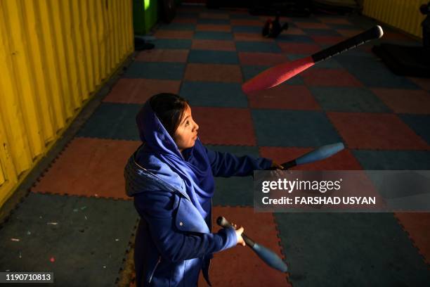 In this photo taken on December 28 a girl learns how to juggle with clubs at the Mobile Mini Circus for Children , an Afghanistan's travelling...