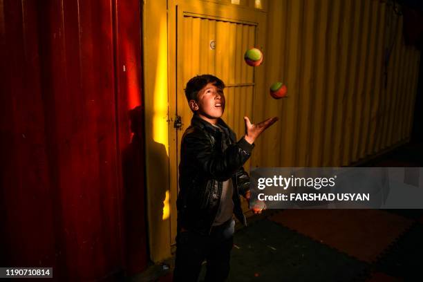 In this photo taken on December 28 a boy learns how to juggle with balls at the Mobile Mini Circus for Children , an Afghanistan's travelling...