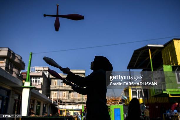 In this photo taken on December 28 a girl learns how to juggle with clubs at the Mobile Mini Circus for Children , an Afghanistan's travelling...