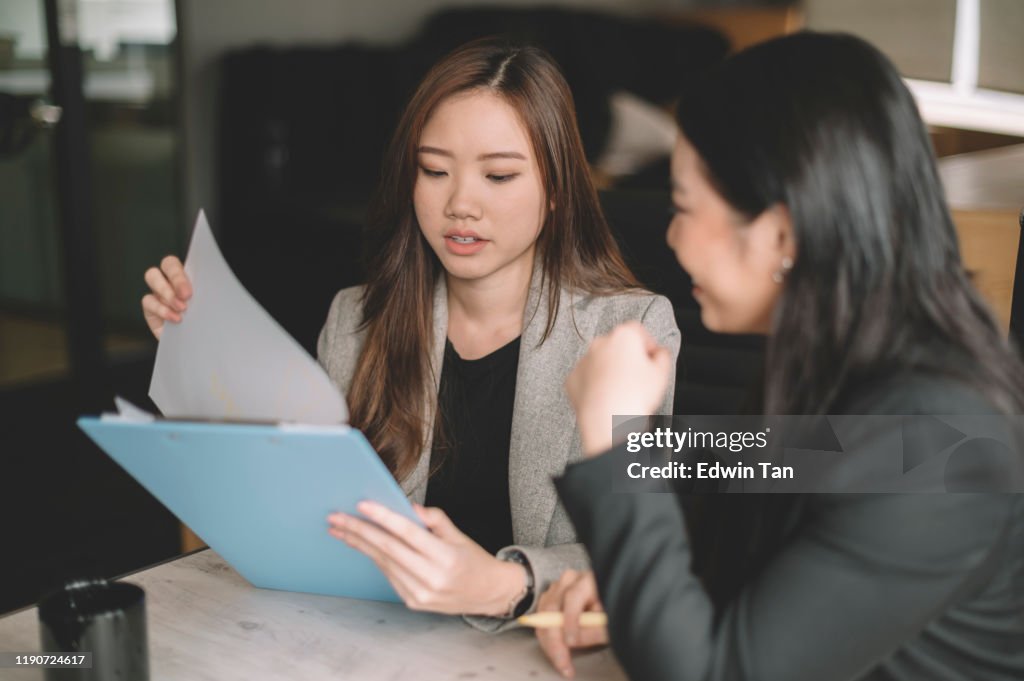 2 vrouwelijke werknemer witte kraag zittend en met discussie over de Business Planning Checklist