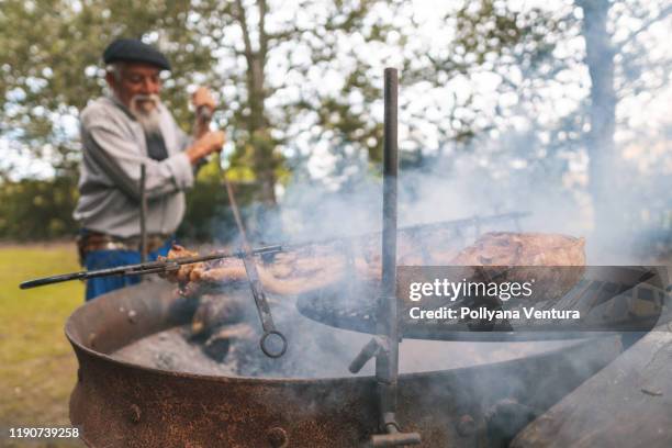 argentinischer senior bereitet sich vor - smoked bbq ribs stock-fotos und bilder