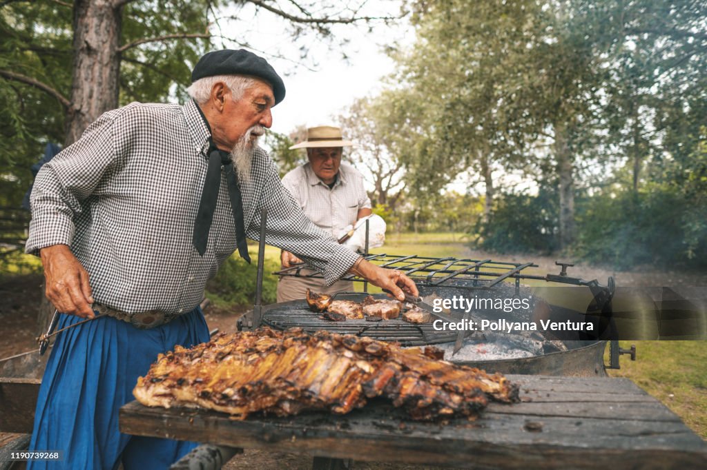 Männer bereiten einen Rippengrill im Brennholz