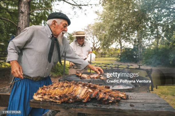 män förbereder en rib grill i brasved - argentinsk kultur bildbanksfoton och bilder