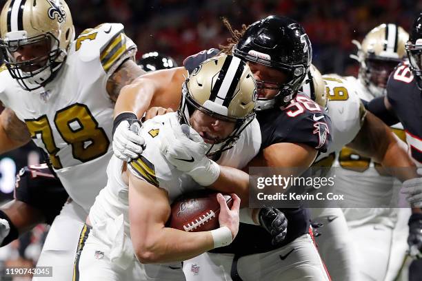 Taysom Hill of the New Orleans Saints breaks a tackle from Tyeler Davison of the Atlanta Falcons as he runs for a touchdown during the first quarter...