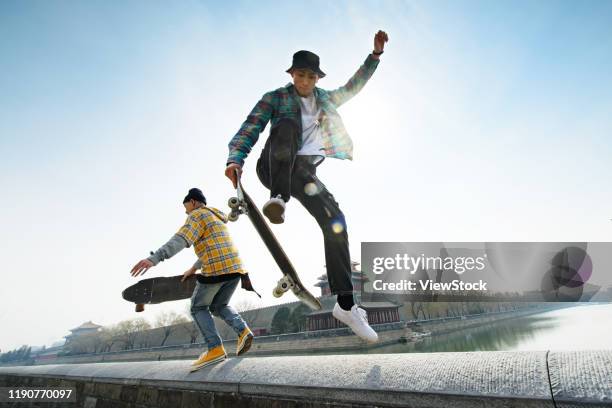 young people skateboarding - attitude youthful asian stock-fotos und bilder