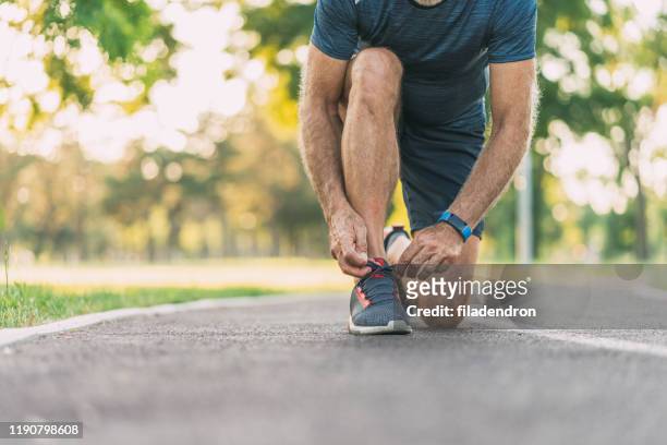 sportsman tying shoelaces - desamarrado imagens e fotografias de stock