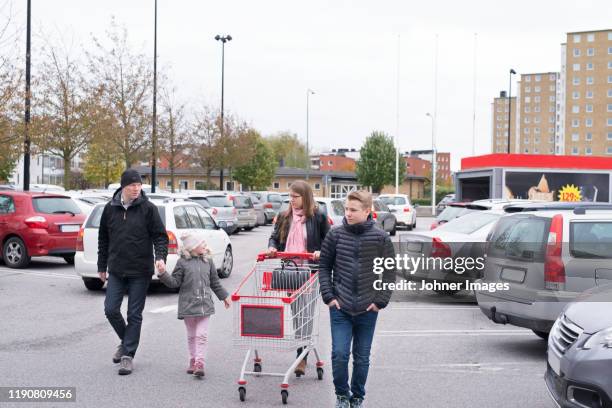 family on store parking - parkplatz stock-fotos und bilder