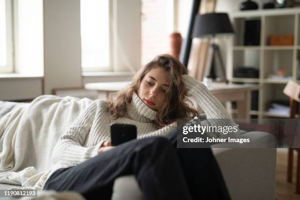 young woman using cell phone - young woman using smartphone at home stock-fotos und bilder