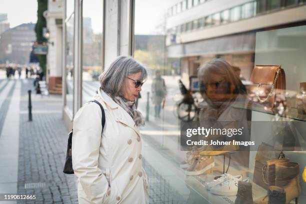 woman looking in shop window - window display stock pictures, royalty-free photos & images