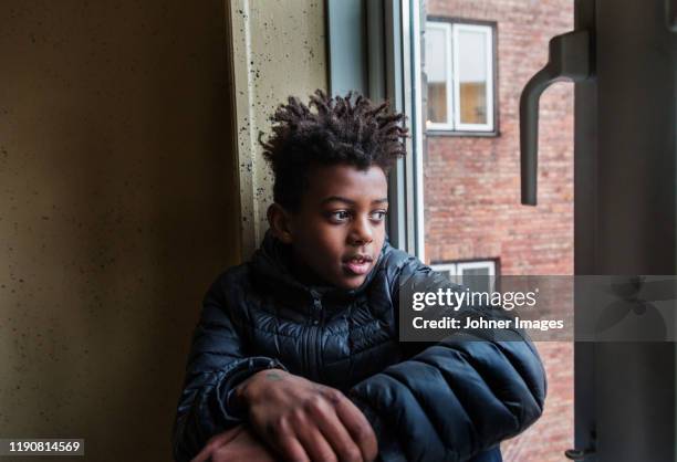 boy looking away - teenage boy looking out window stock pictures, royalty-free photos & images