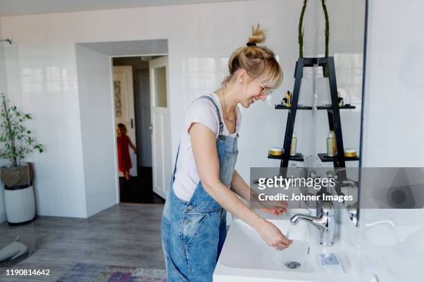 smiling woman washing hands - housework stock pictures, royalty-free photos & images