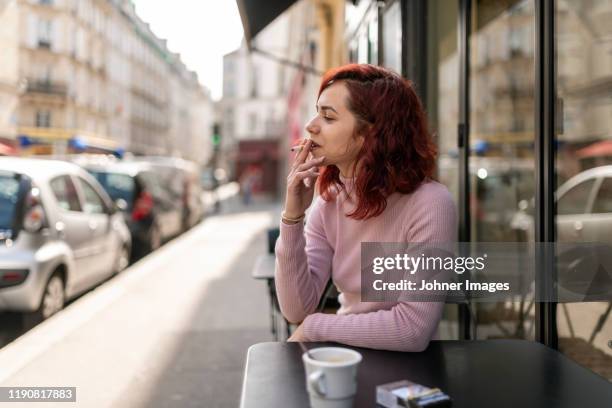 woman smoking in outdoor cafe - fumer du tabac photos et images de collection