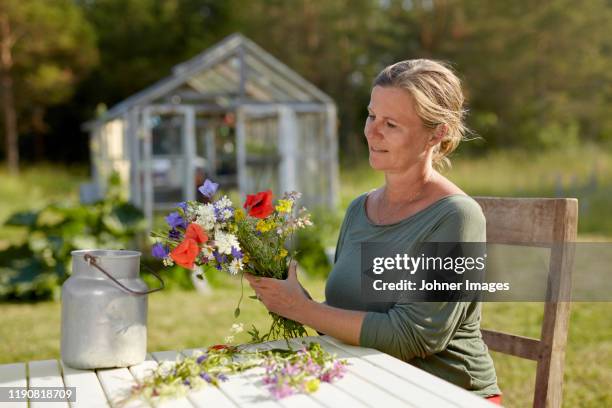 woman holding wildflowers - midsommar stock pictures, royalty-free photos & images