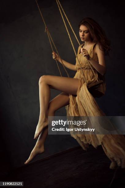 young sensual woman in long dress swinging - woman on swing stock pictures, royalty-free photos & images