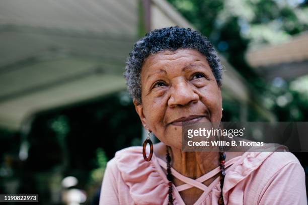 close-up portrait of senior black woman looking thoughtful - portrait close up stock-fotos und bilder