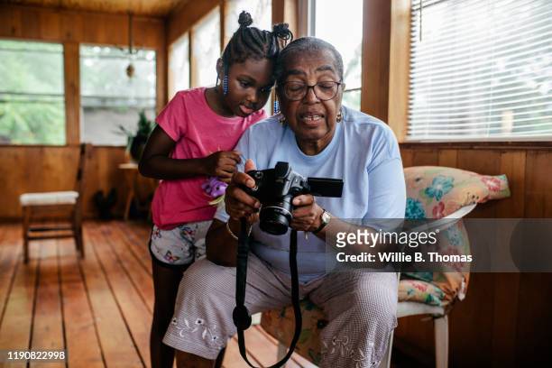 Black grandmother and granddaughter looking at photos