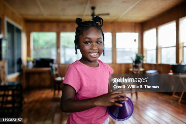 portrait of young black girl looking into the camera"n - african child girl stock-fotos und bilder
