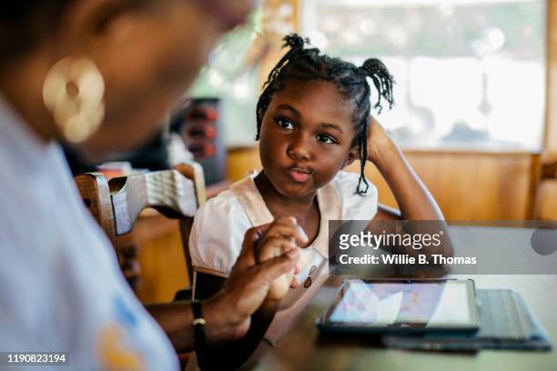 young black child getting help with her homework - flätor bildbanksfoton och bilder