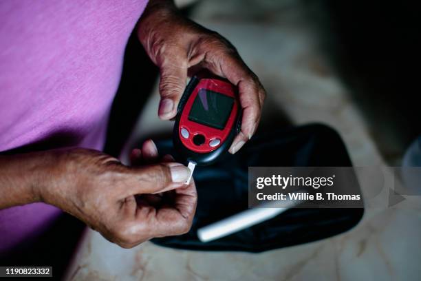 senior using diabetes home test kit - diabetes technology stock pictures, royalty-free photos & images