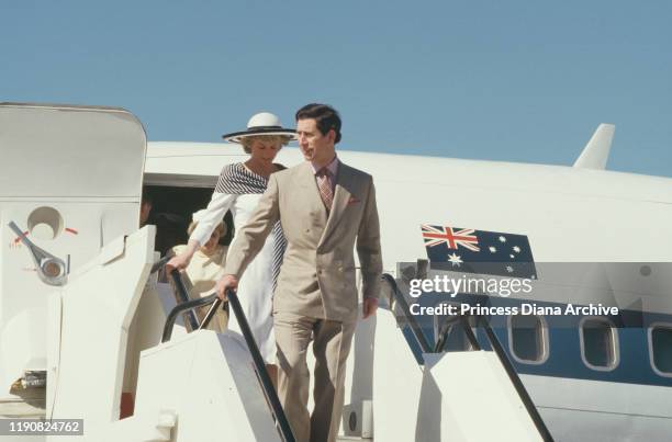 Prince Charles and Diana, Princess of Wales arrive at Sydney airport, Australia, January 1988. Diana is wearing a dress by Catherine Walker.