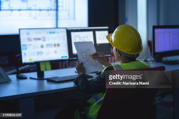 industrial engineering works in front of monitoring screen in the production control center. technology concept. - government intelligence stock pictures, royalty-free photos & images