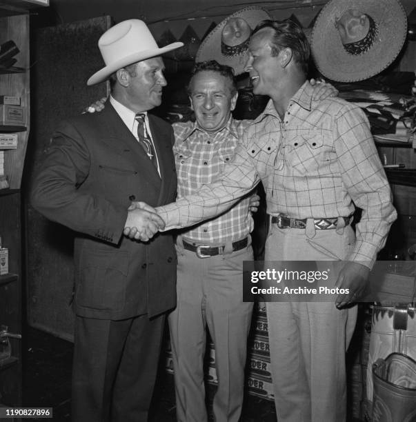 From left to right, actor and singer Gene Autry , tailor Nudie Cohn and actor and singer Roy Rogers at a party for Cohn and various Western stars,...