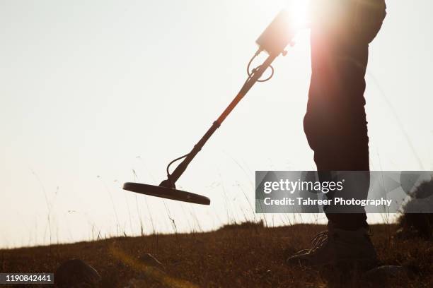 a man finding treasure using metal detector - artifact stock pictures, royalty-free photos & images