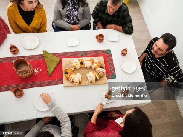 mexican people celebrating dia de reyes at table - rosca de reyes stock pictures, royalty-free photos & images