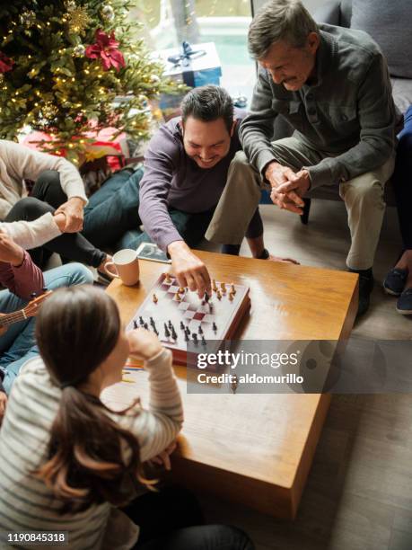 glücklicher vater und tochter spielen schach am weihnachtstag - familie brettspiel stock-fotos und bilder