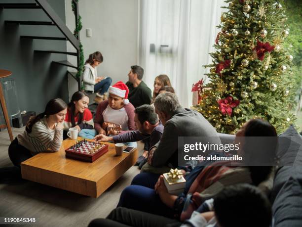 latin family playing chess on christmas - board games imagens e fotografias de stock