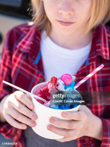 detail shot of young person holding colorful shave ice - shaved ice stockfoto's en -beelden