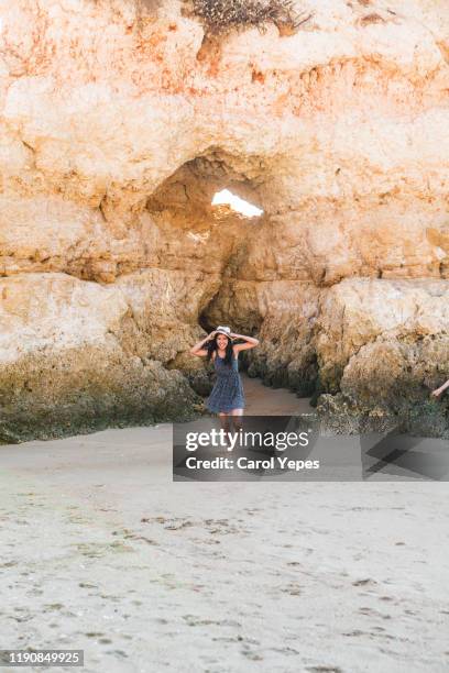 cheerful young woman running in rocky beach,algarve,portugal - lagos portugal stockfoto's en -beelden