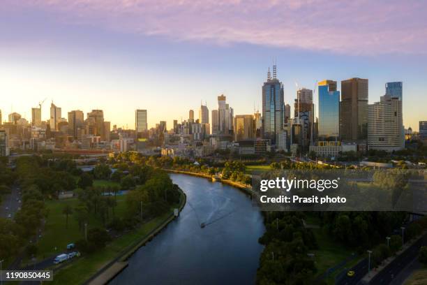 sunset view of yarra river and melbourne skyscrapers business office building with evening skyline in victoria, australia. australia tourism, modern city life, or business finance and economy concept - aerial melbourne fotografías e imágenes de stock