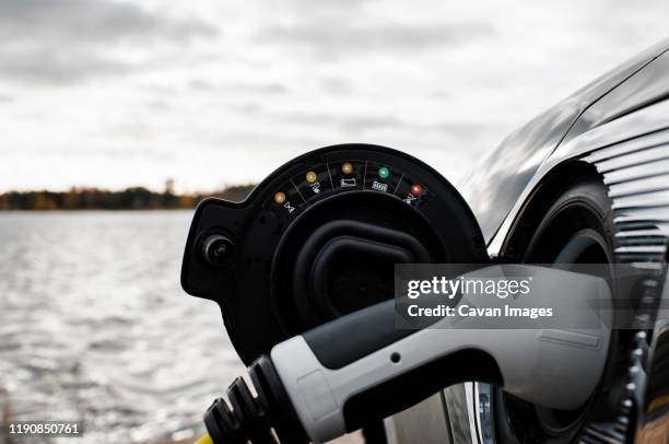 electric car charging socket and lead by the beach - car electro stock pictures, royalty-free photos & images